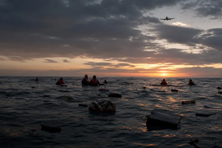 Naufraghi della USS Indianapolis in mare all'alba tra rottami e onde scure