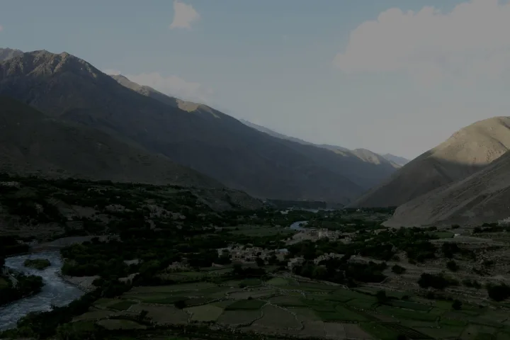 Valle montana afghana sotto una luce scura e fredda, lontana dalla stanza dell’intervista